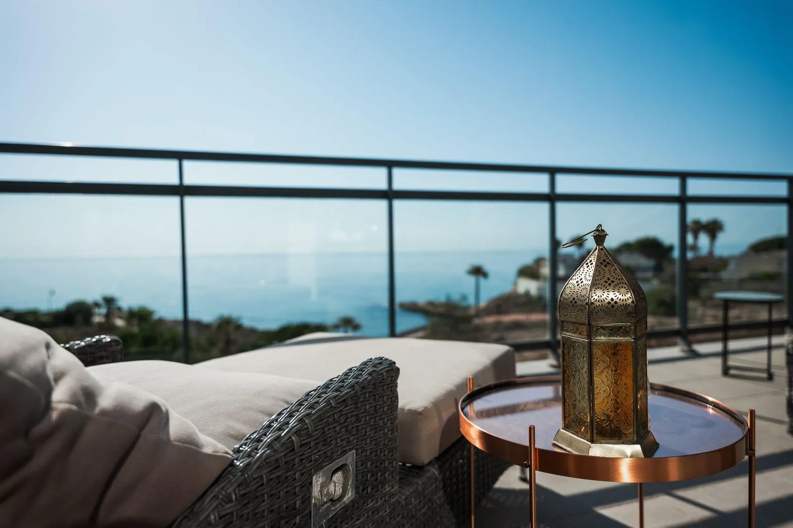 Meerblick von einem Balkon mit orientalischer Laterne und Liegestuhl.